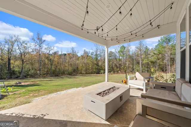 a view of a patio with a table chairs potted plants and palm trees