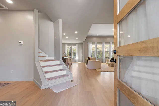 a view of a living room and kitchen with furniture and wooden floor