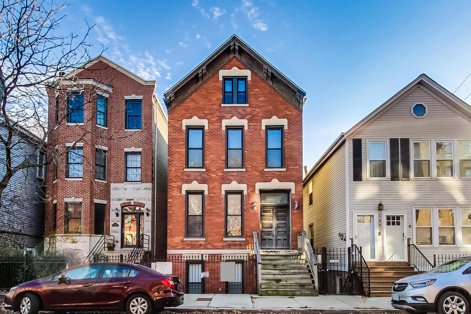 1369 West Crystal Street, Unit 3 Chicago, IL 60642 - Photo 1 of 22 a front view of a residential apartment building with a yard