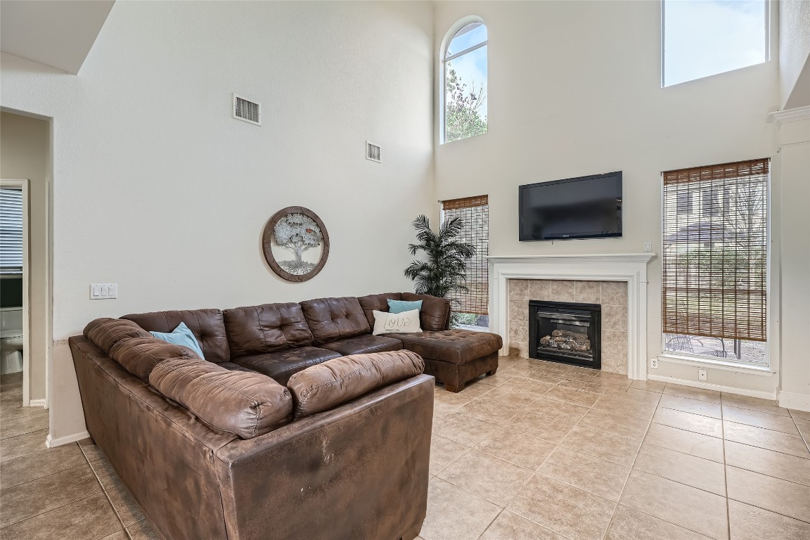 a living room with furniture a fireplace and a flat screen tv
