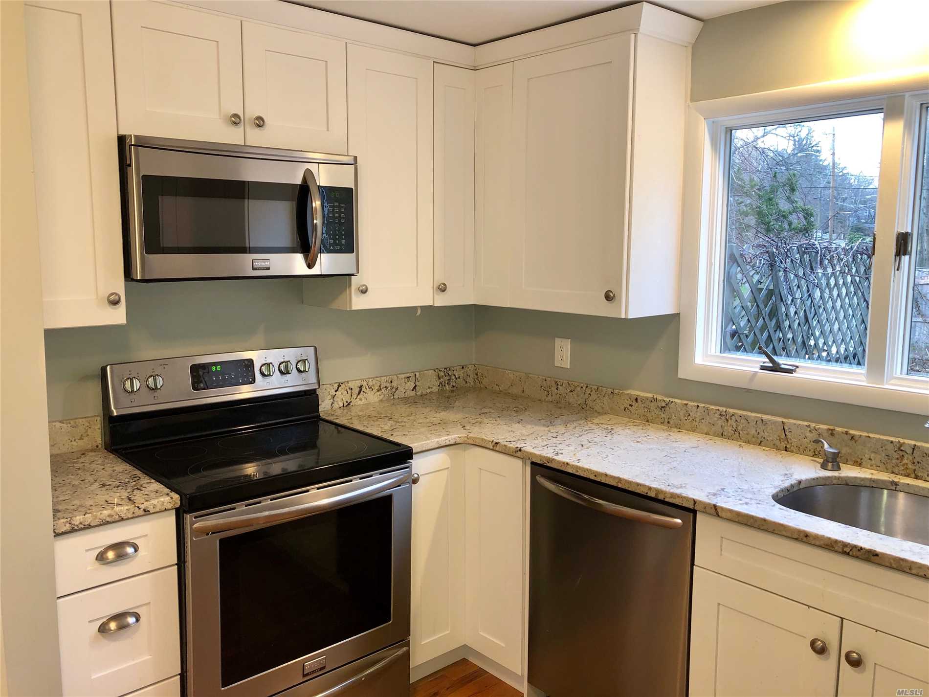 152 Hallock Landing Road Rocky Point, NY 11778 - Photo 1 of 1 a kitchen with granite countertop white cabinets stainless steel appliances and window