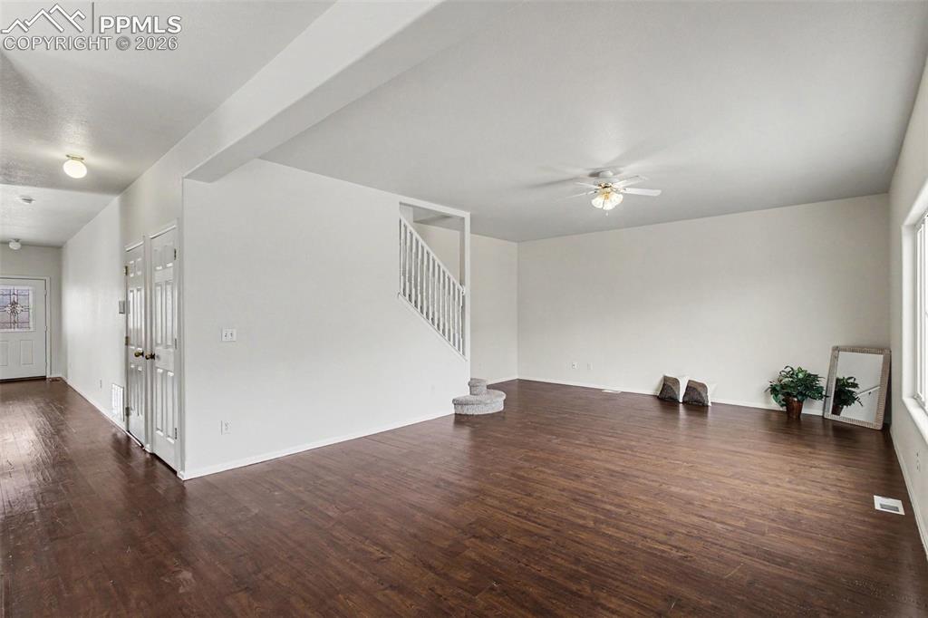 12210 Crystal Downs Road Peyton, CO 80831 - Photo 6 of 40 a view of an empty room with wooden floor and a ceiling fan