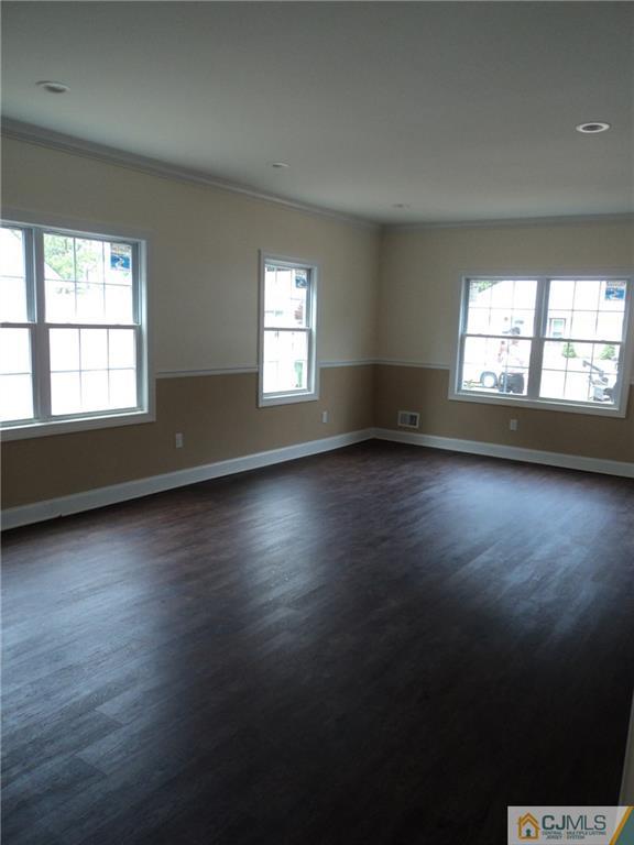 38 Markham Road Edison, NJ 08817 - Photo 4 of 9 an empty room with wooden floor and windows
