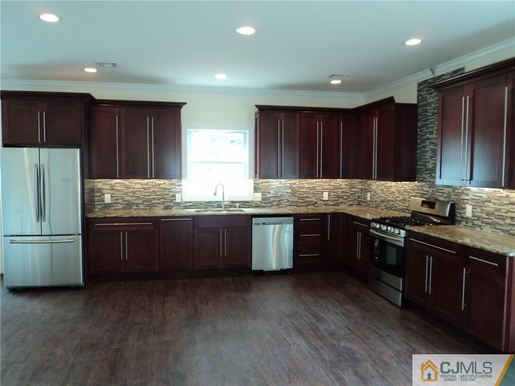 38 Markham Road Edison, NJ 08817 - Photo 5 of 9 a kitchen with kitchen island granite countertop stainless steel appliances and wooden cabinets