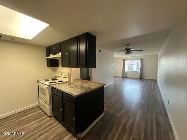 a kitchen with a stove and wooden floor