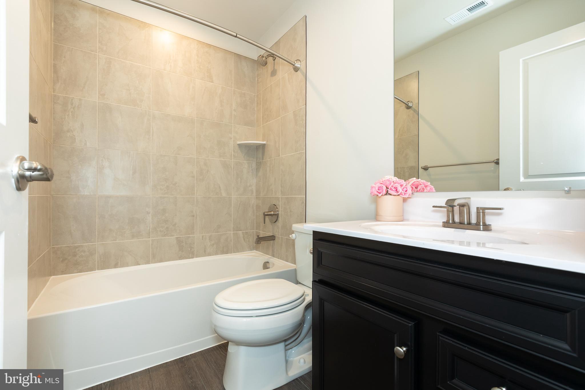 180 Woodgate Circle, Unit CLARENDON3 Pasadena, MD 21122 - Photo 14 of 47 a bathroom with a sink a toilet and shower