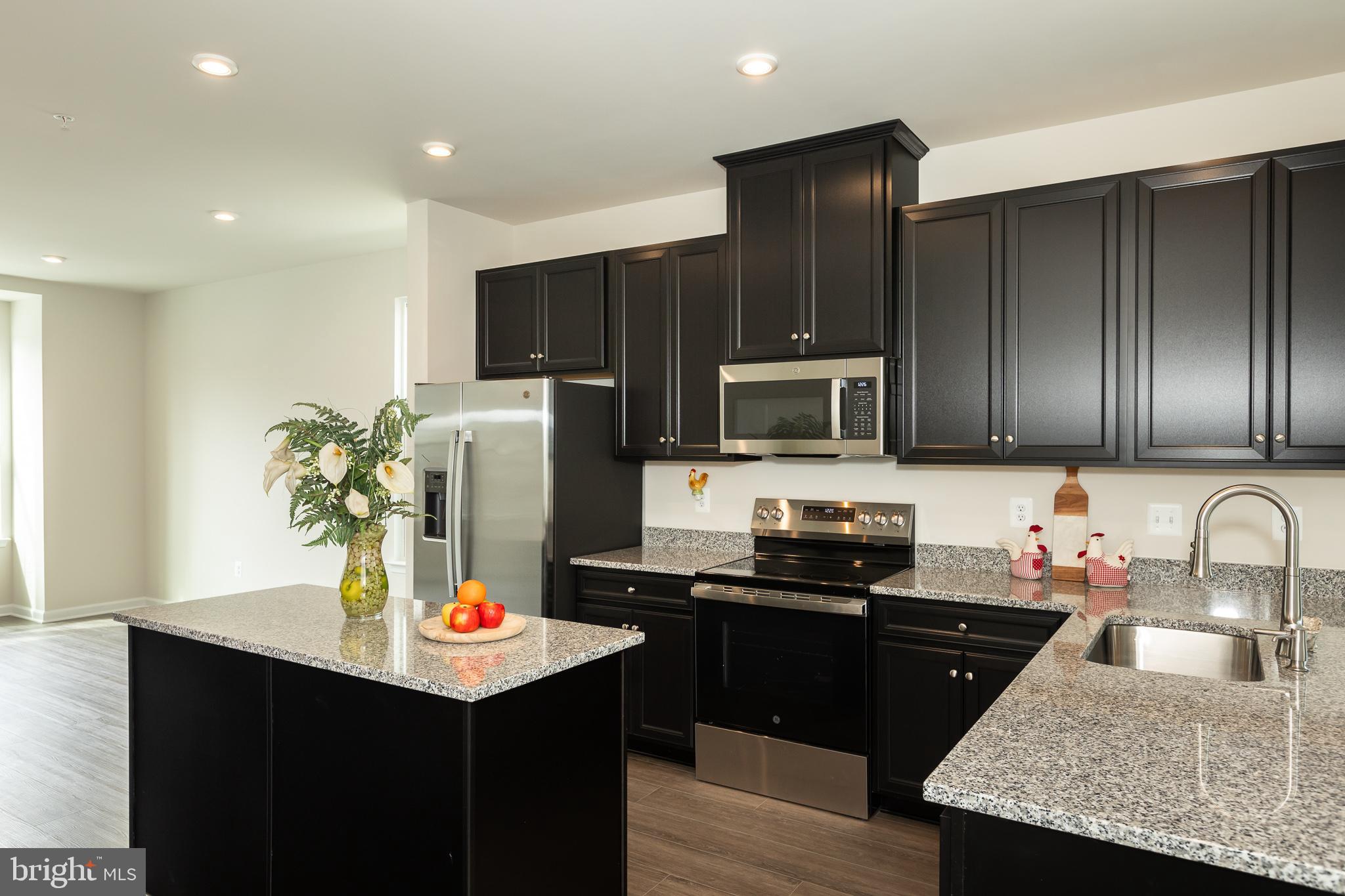 180 Woodgate Circle, Unit CLARENDON3 Pasadena, MD 21122 - Photo 25 of 47 a kitchen with stainless steel appliances granite countertop a refrigerator a sink and a stove