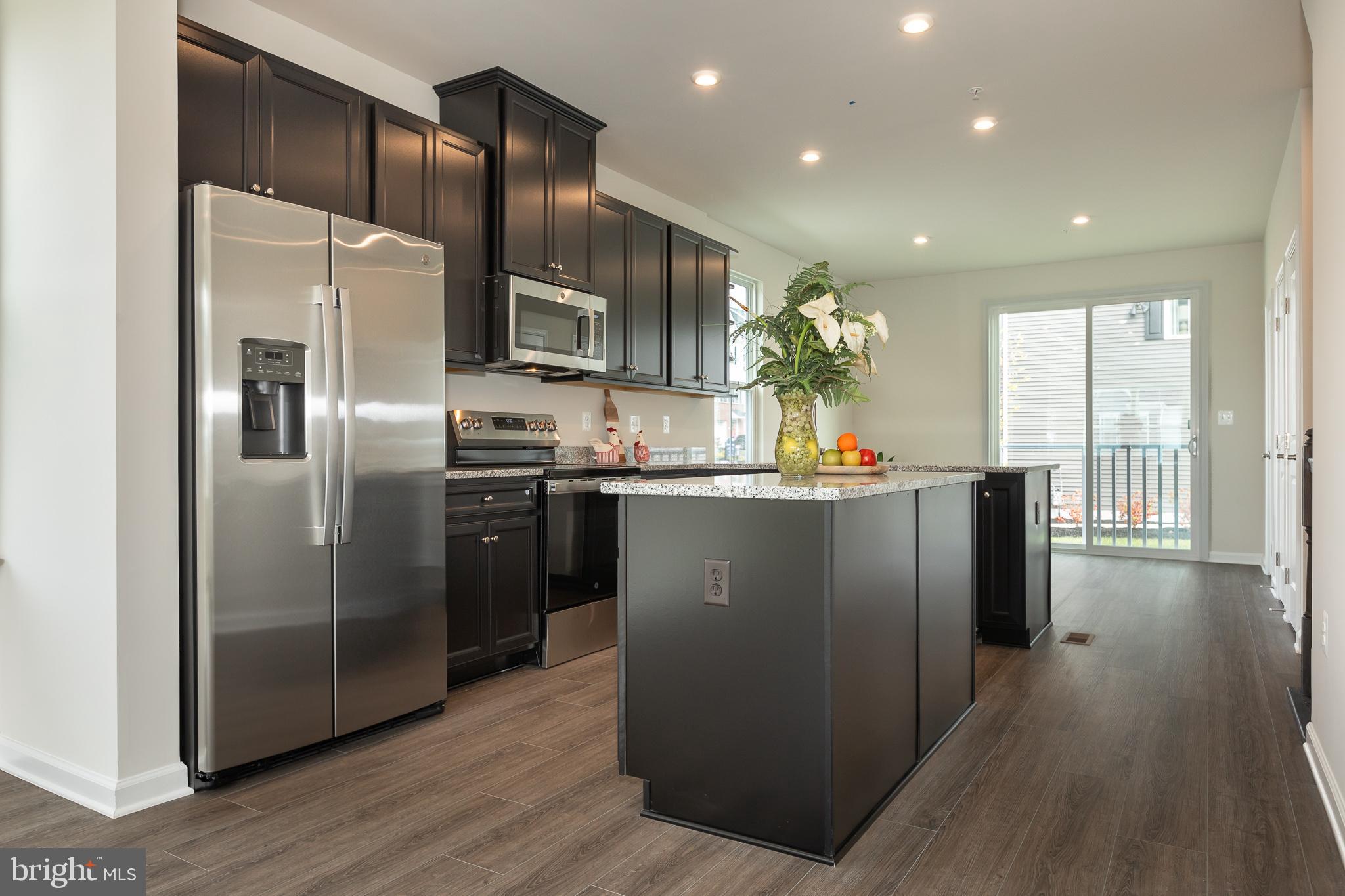 180 Woodgate Circle, Unit CLARENDON3 Pasadena, MD 21122 - Photo 27 of 47 a kitchen with stainless steel appliances granite countertop a refrigerator a sink a stove and oven