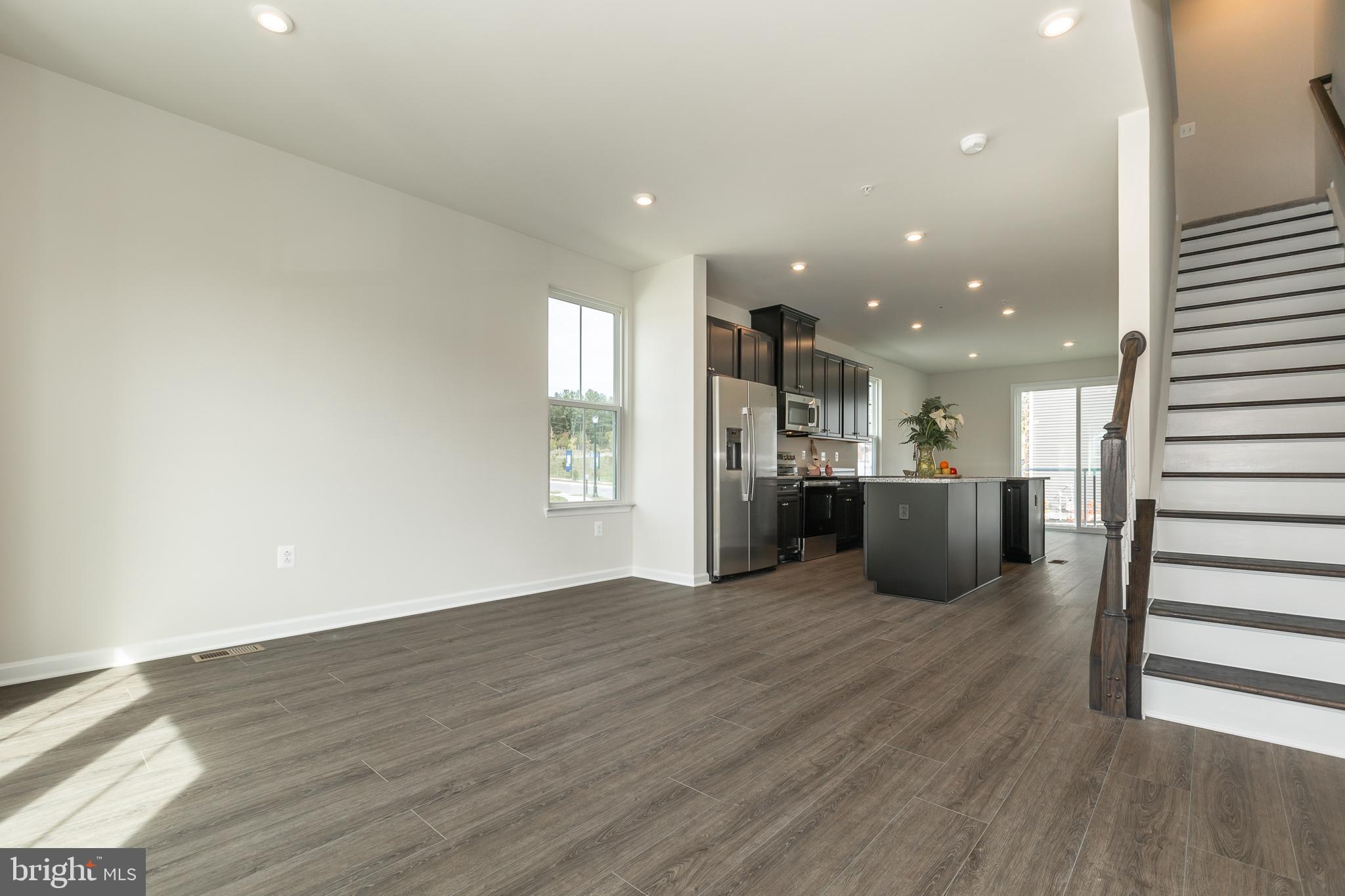 180 Woodgate Circle, Unit CLARENDON3 Pasadena, MD 21122 - Photo 31 of 47 a view of a big room with wooden floor and windows