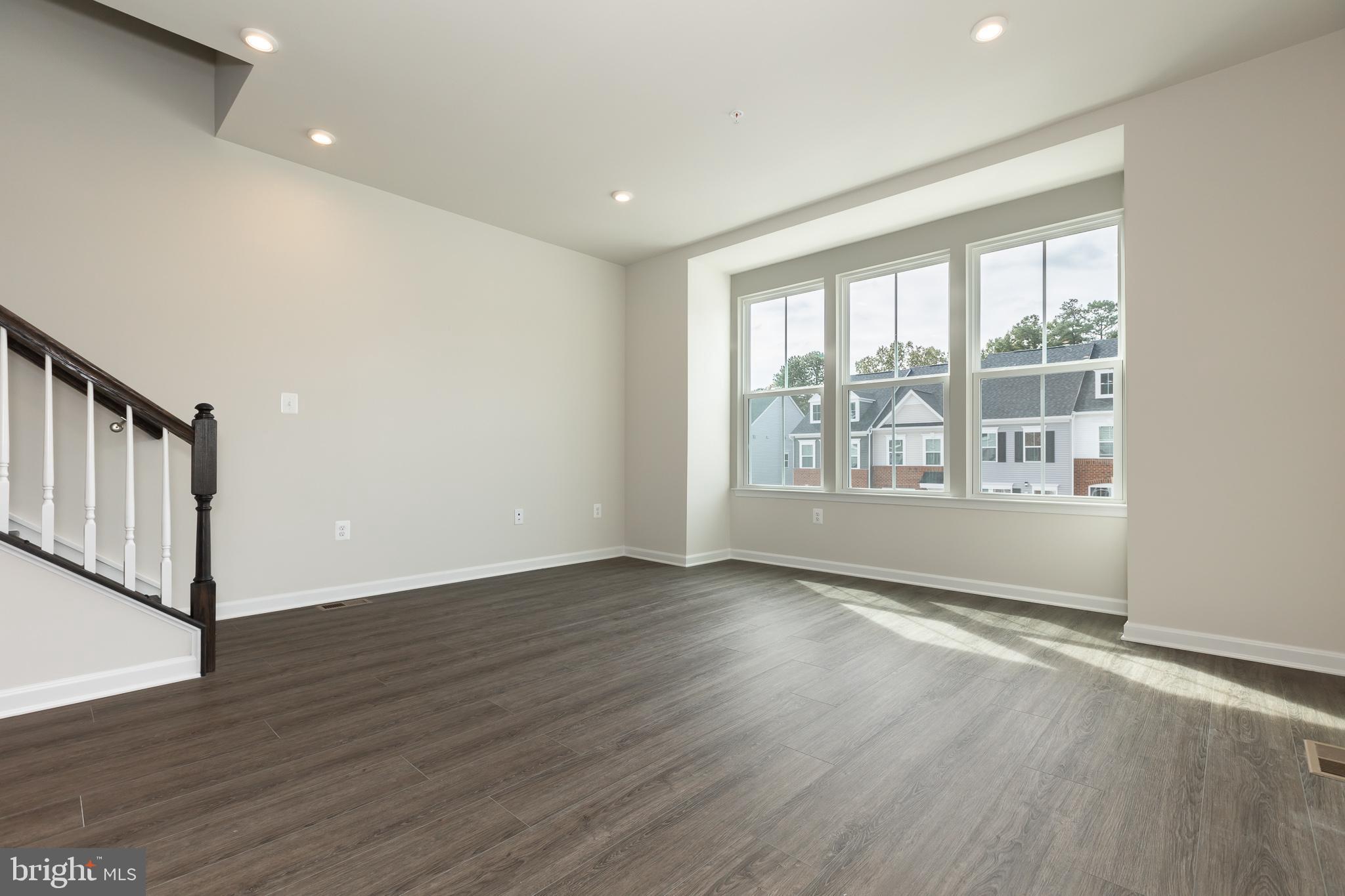 180 Woodgate Circle, Unit CLARENDON3 Pasadena, MD 21122 - Photo 33 of 47 a view of an empty room with wooden floor and a window