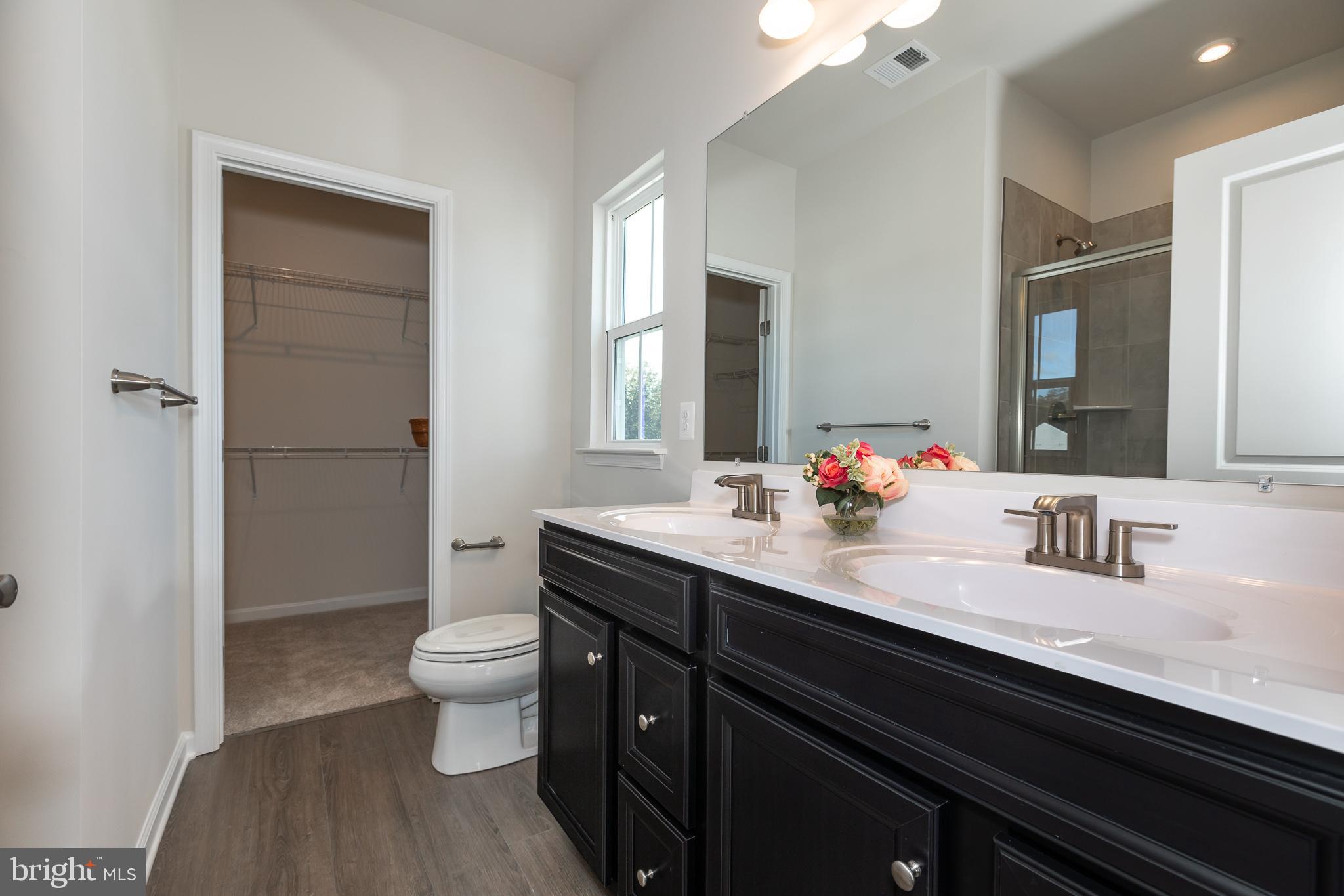 180 Woodgate Circle, Unit CLARENDON3 Pasadena, MD 21122 - Photo 38 of 47 a bathroom with a double vanity sink toilet and a mirror