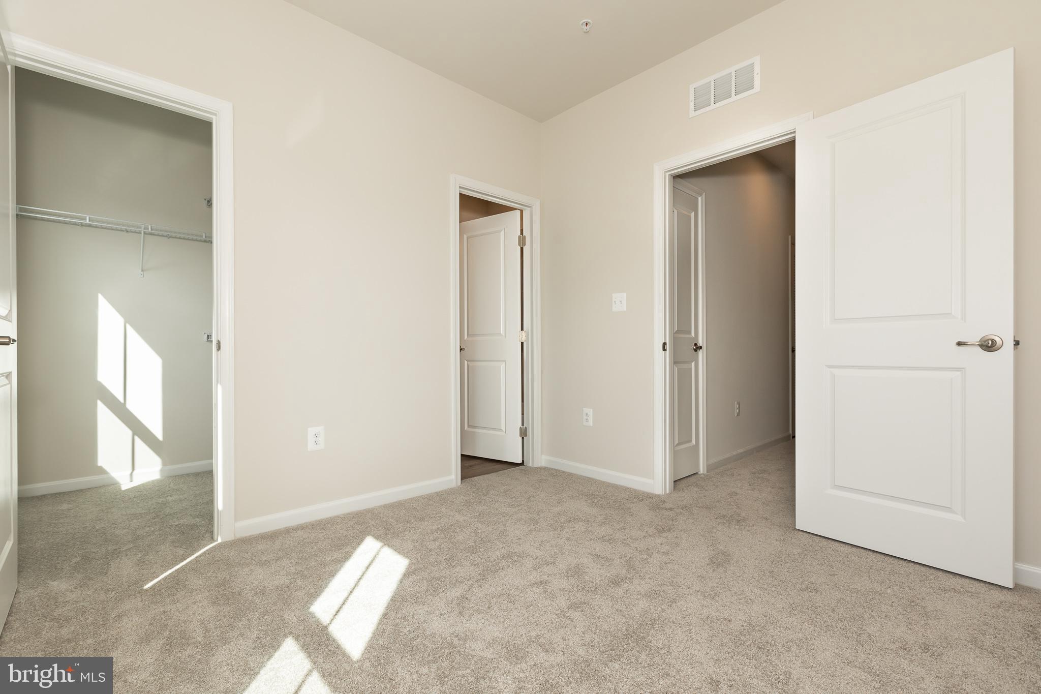 180 Woodgate Circle, Unit CLARENDON3 Pasadena, MD 21122 - Photo 44 of 47 an empty room with windows and closet