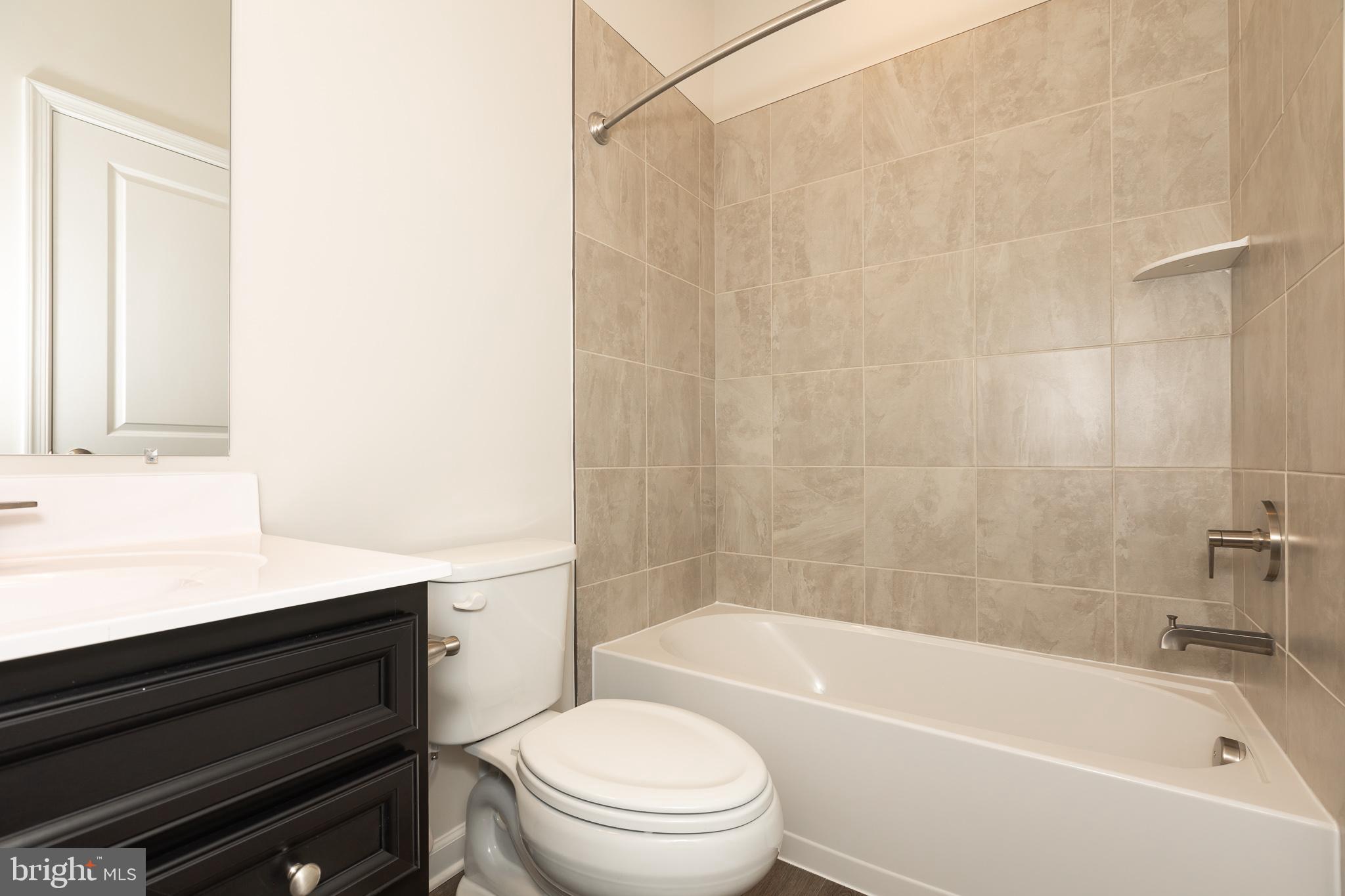 180 Woodgate Circle, Unit CLARENDON3 Pasadena, MD 21122 - Photo 47 of 47 a bathroom with a bathtub shower sink vanity and toilet