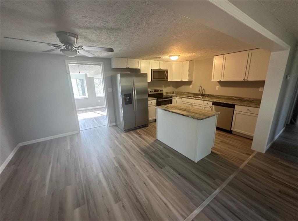 93 Church Road Eighty Four, PA 15330 - Photo 6 of 14 a kitchen with stainless steel appliances a refrigerator a sink dishwasher a stove top oven a refrigerator and white cabinets with wooden floor