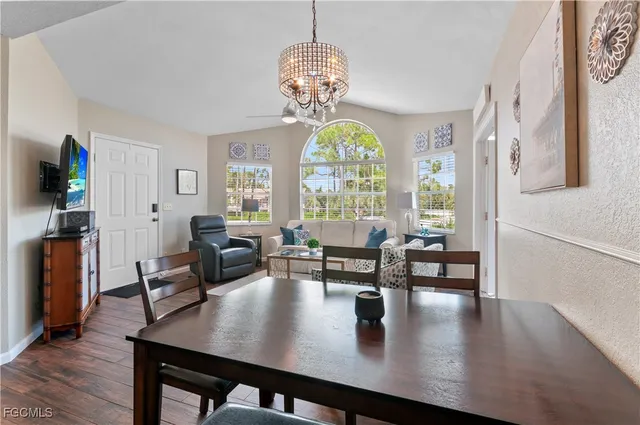 a view of a dining room with furniture a chandelier and wooden floor