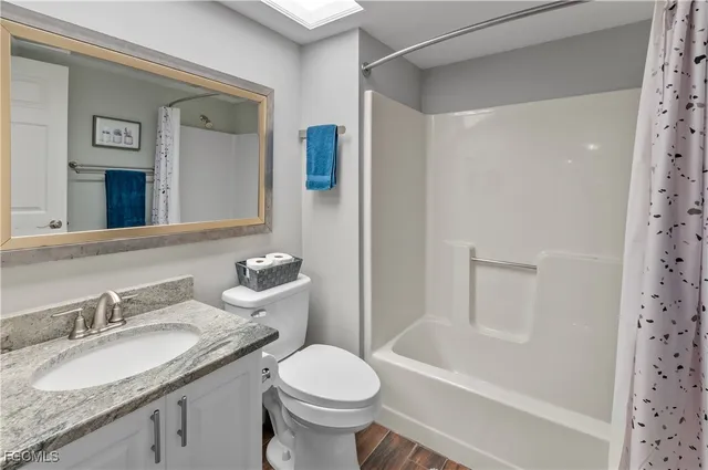a bathroom with a granite countertop sink toilet and shower