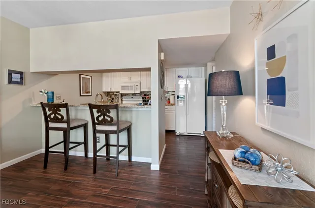 a kitchen with stainless steel appliances a dining table chairs and wooden floor