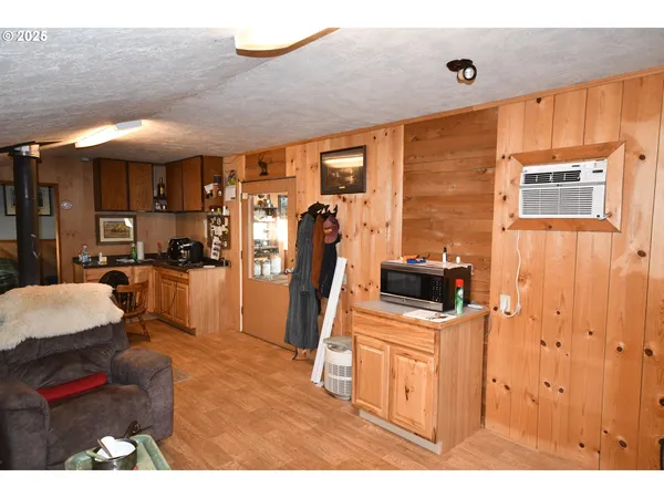 a living room with furniture a flat screen tv and a refrigerator