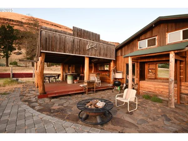 a backyard of a house with barbeque oven table and chairs