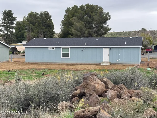 an aerial view of a house with a yard and mountain view in back