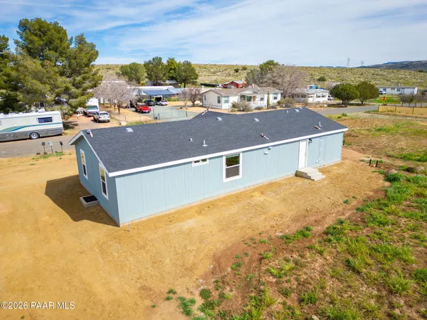 an aerial view of residential houses with outdoor space and ocean view