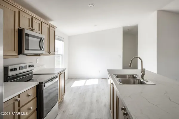 a kitchen with stainless steel appliances granite countertop a sink stove and refrigerator