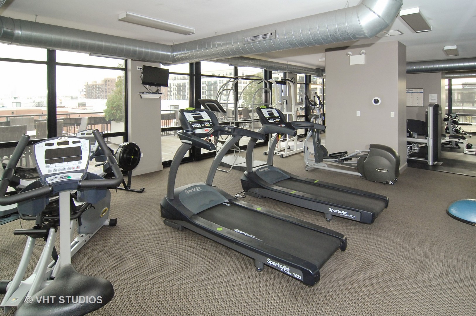 1000 West 15th Street, Unit 235 Chicago, IL 60608 - Photo 14 of 16 a room with gym equipment and large windows