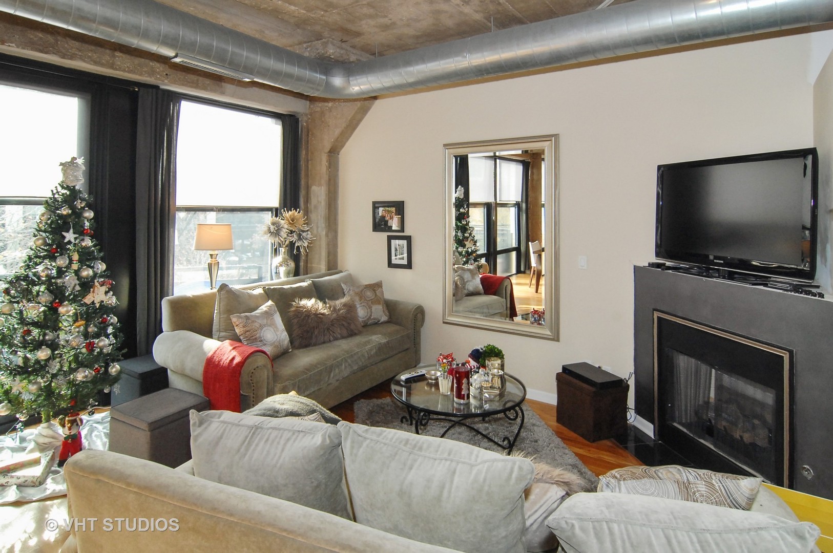 1000 West 15th Street, Unit 235 Chicago, IL 60608 - Photo 8 of 16 a living room with furniture a flat screen tv and a fireplace
