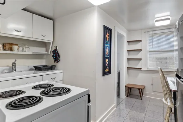 a kitchen with a stove and white cabinets