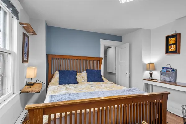 a bedroom with a bed and wooden floor