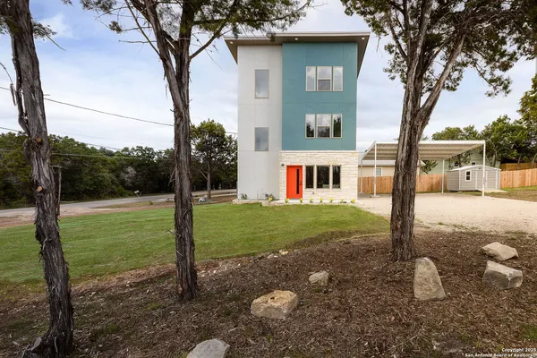 a view of a house with backyard and a tree