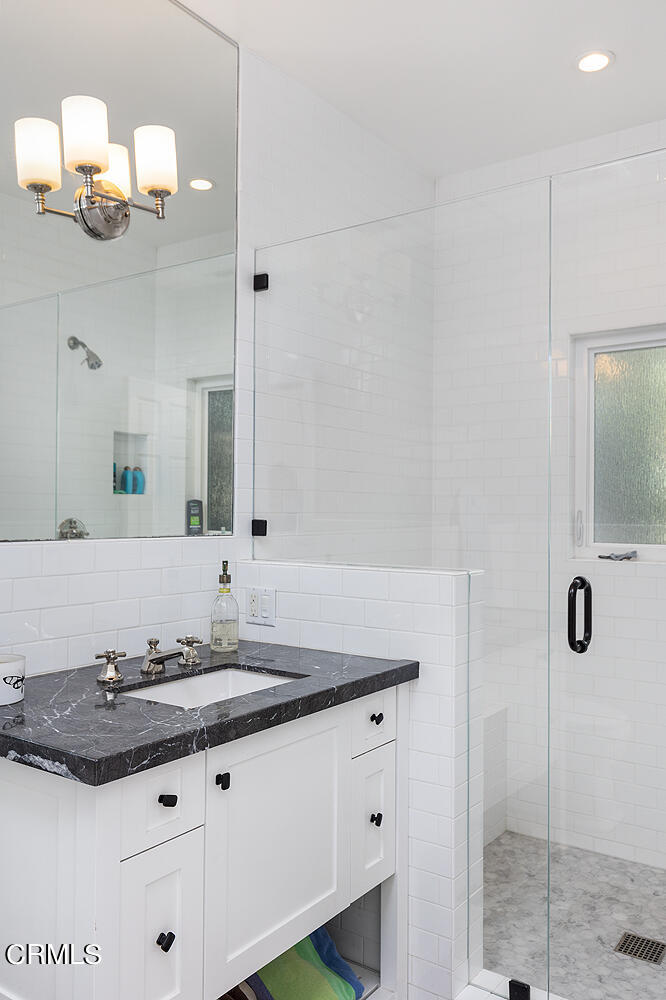 1375 Ridge Way Pasadena, CA 91106 - Photo 30 of 36 a bathroom with a granite countertop sink a mirror and shower