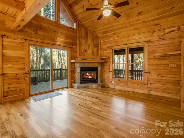 a view of an empty room with wooden floor and a fireplace