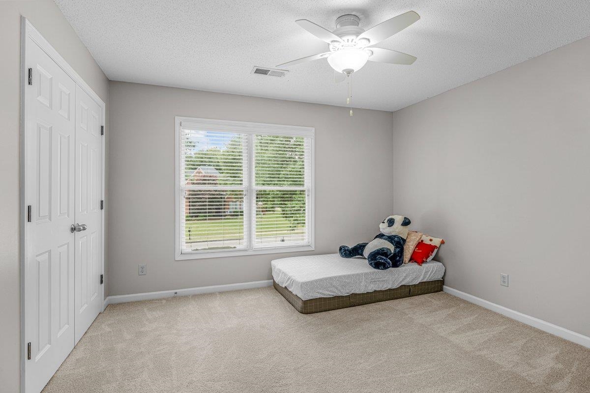 4840 Rainy Pass Road Collierville, TN 38017 - Photo 25 of 30 Neutral-toned room featuring a double window with blinds, a ceiling fan with integrated lighting, and a double-door closet