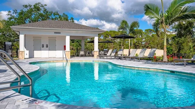 a view of a swimming pool with a patio and plants