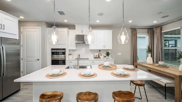 a living room with furniture kitchen view and a large window