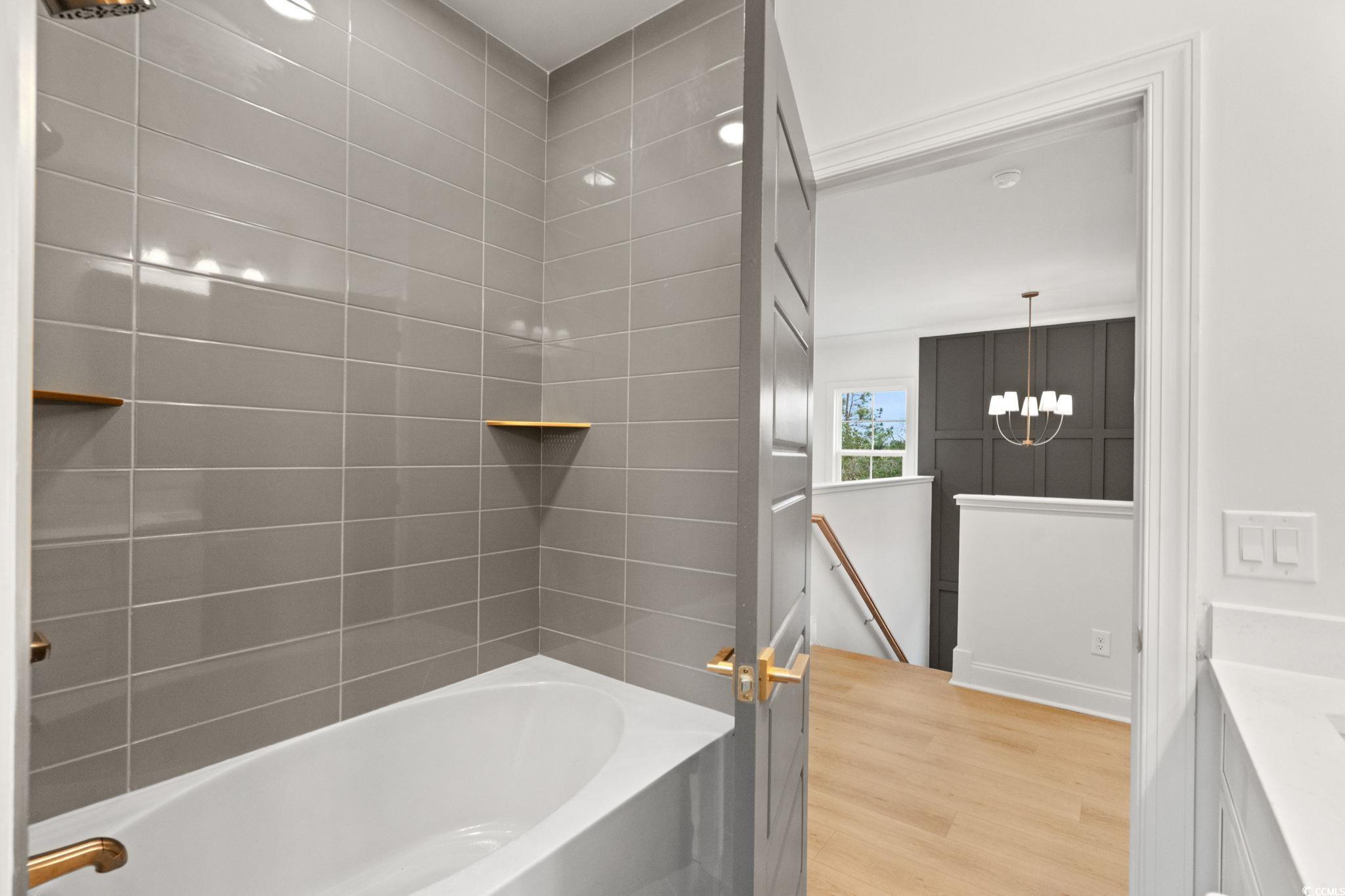 144 Arbor Ridge Circle Conway, SC 29526 - Photo 32 of 40 Bathroom with light wood-style flooring, tub / shower combination, vanity, and a chandelier