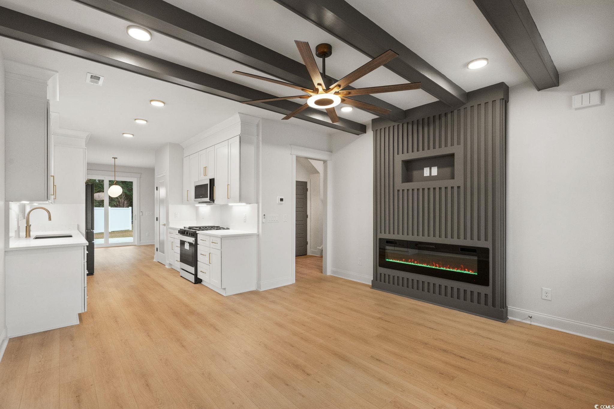 144 Arbor Ridge Circle Conway, SC 29526 - Photo 6 of 40 Unfurnished living room featuring beam ceiling, a ceiling fan, light wood-style flooring, recessed lighting, and a glass covered fireplace
