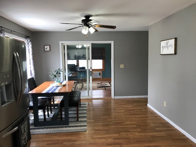 14475 Waller Road Albany, IL 61230 - Photo 5 of 22 a dining room with wooden floor a chandelier a glass table and chairs