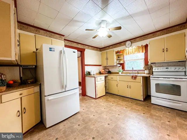 a kitchen with white cabinets and white stainless steel appliances