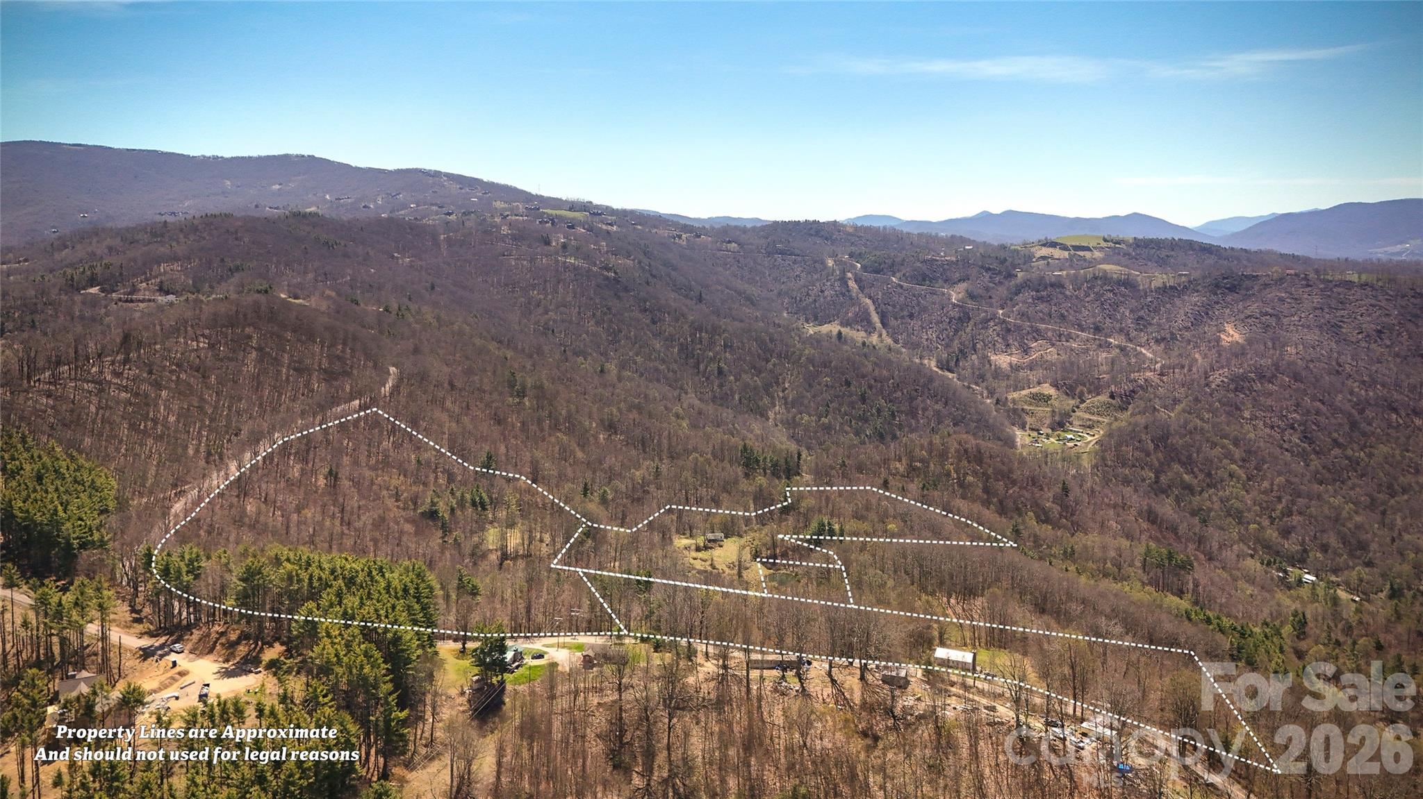 7277 Beech Mountain Road Elk Park, NC 28622 - Photo 1 of 12 a view of a mountain in the distance in a field