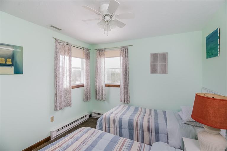 230 Salt Works Road Eastham, MA 02642 - Photo 27 of 35 a bedroom with a bed and wooden floor