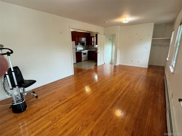 a view of a room with wooden floor and furniture