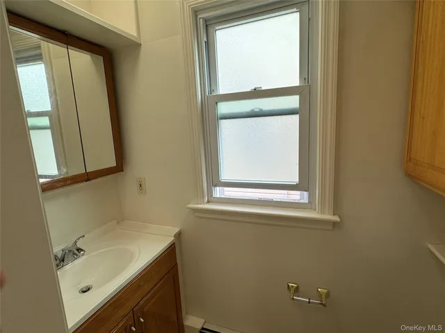 a bathroom with a sink and mirror with window