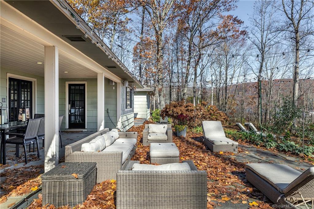 a view of a patio with couches table and chairs and potted plants