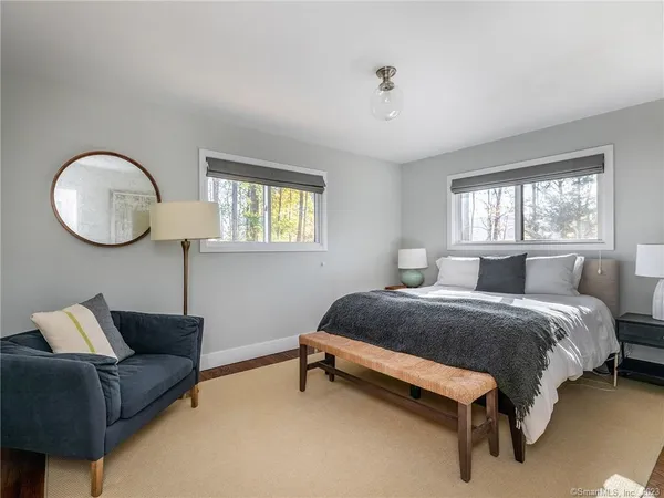 a spacious bedroom with a bed couch and window