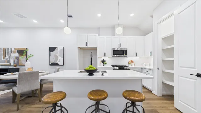 a kitchen with kitchen island a counter space a sink stainless steel appliances and cabinets