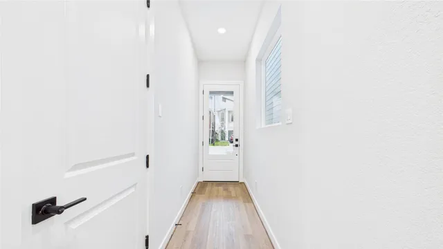 a view of a hallway with wooden floor and a large window