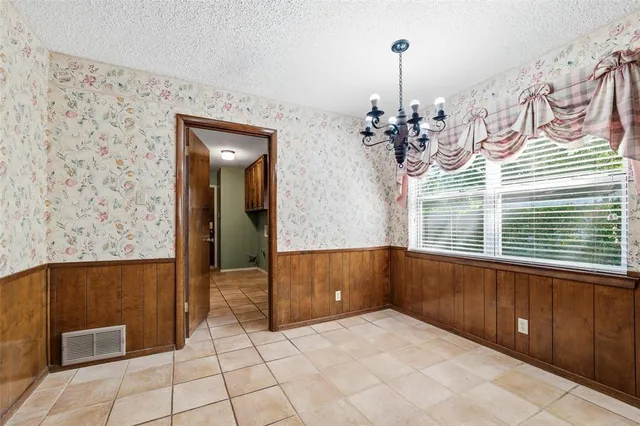 a view of a livingroom with wooden floor and a chandelier