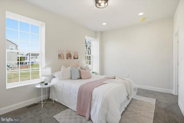 a bedroom with a bed and a view of living room